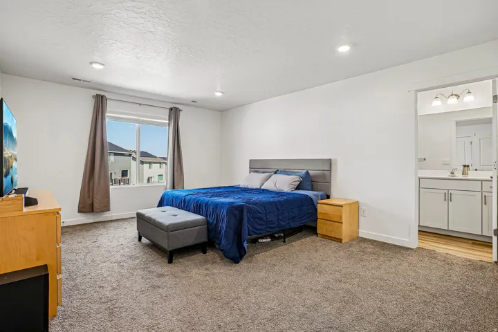 Carpeted room with a large window and recessed lighting