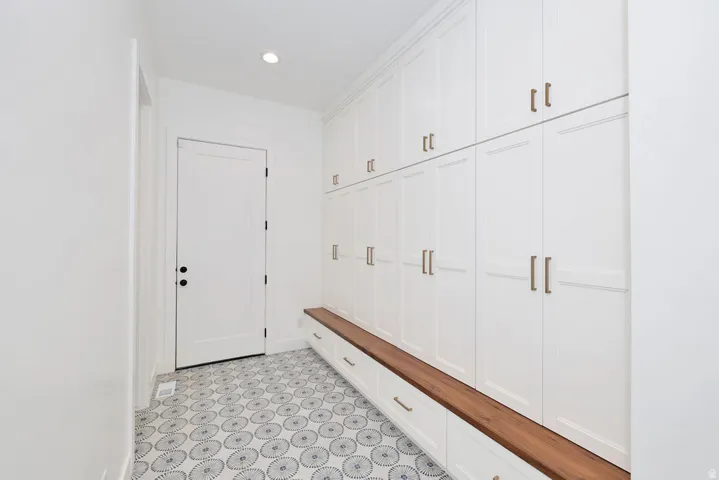 Entryway featuring extensive white cabinetry with bronze hardware
