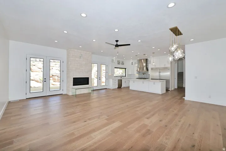 Open-concept living space featuring gleaming wood-finish flooring throughout, recessed ceiling lighting, and a ceiling fan