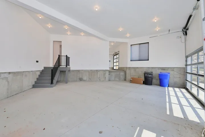 Spacious industrial-style interior featuring polished concrete flooring, exposed concrete wainscoting, and recessed ceiling lighting throughout