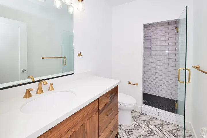 Bathroom featuring a wood-finish vanity with a white countertop and gold-tone fixtures
