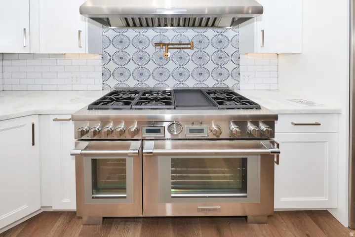 Stainless steel range with double ovens set into white cabinetry