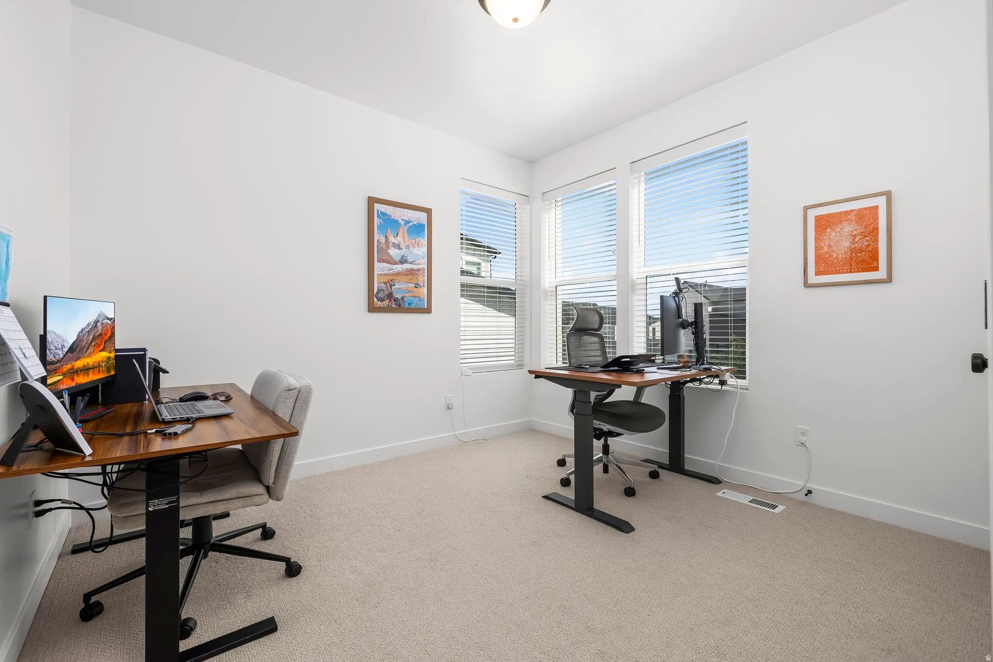 Bright room featuring plush carpeting, white walls, and multiple windows with horizontal blinds