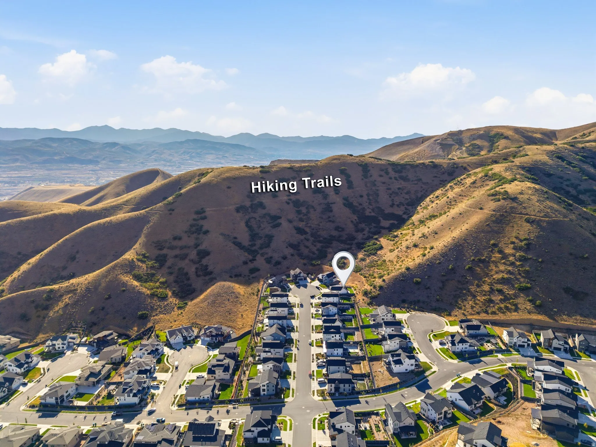 Residential community situated at the base of expansive hillsides, featuring hiking trails