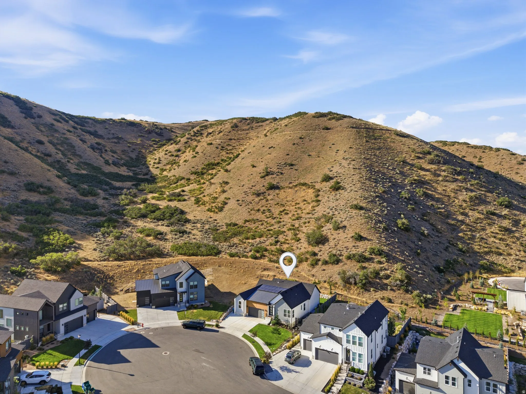 Modern property featuring a light-colored exterior and dark roof situated on a cul-de-sac