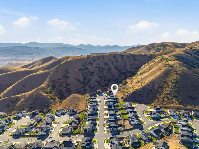 Aerial perspective showcasing a residential community nestled against a mountainous backdrop