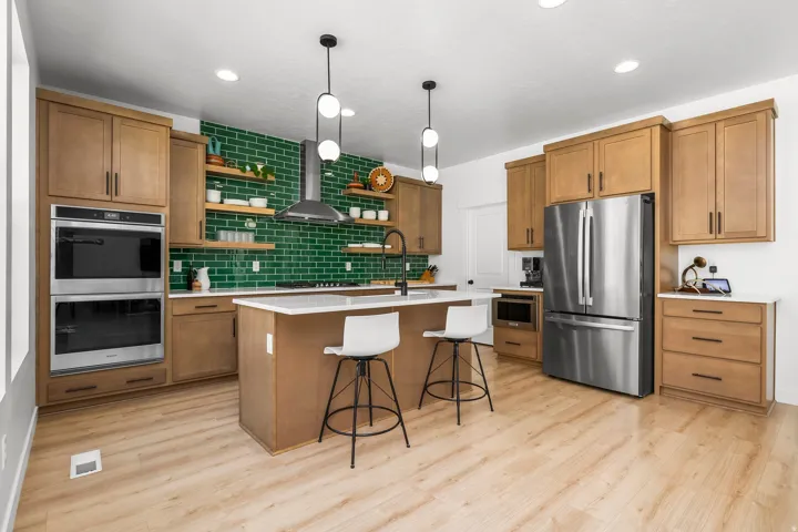 Modern kitchen featuring a central island with countertop seating, wood-finish flooring, and recessed lighting