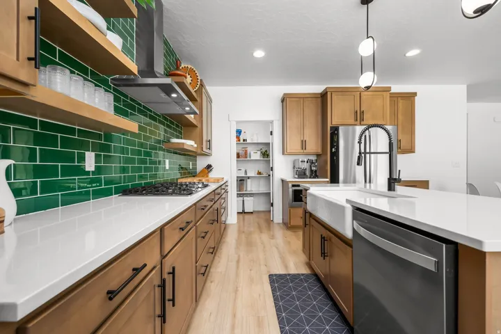 Modern kitchen featuring a vibrant green subway tile backsplash and warm wood-finish cabinetry