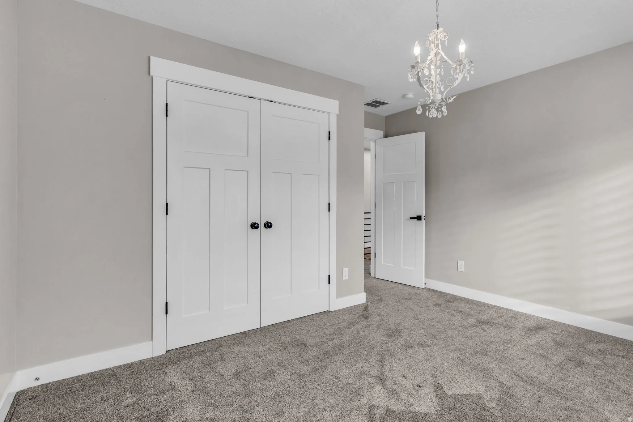 Interior room featuring neutral wall color, grey carpet, and white trim