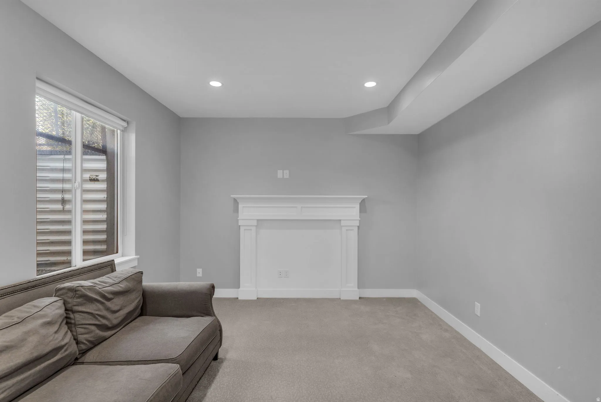 Living area featuring a decorative white mantel, recessed lighting, neutral gray walls, and carpet flooring