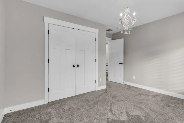 Interior room featuring neutral wall color, grey carpet, and white trim