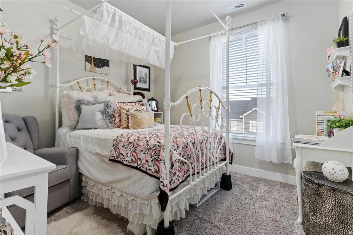 BEDROOM 2 -Carpeted room featuring a window with blinds and sheer curtains, light-toned walls, and white trim