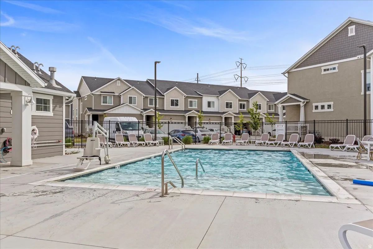 AMENITIES - Community swimming pool with concrete decking, featuring built-in steps and metal handrails
