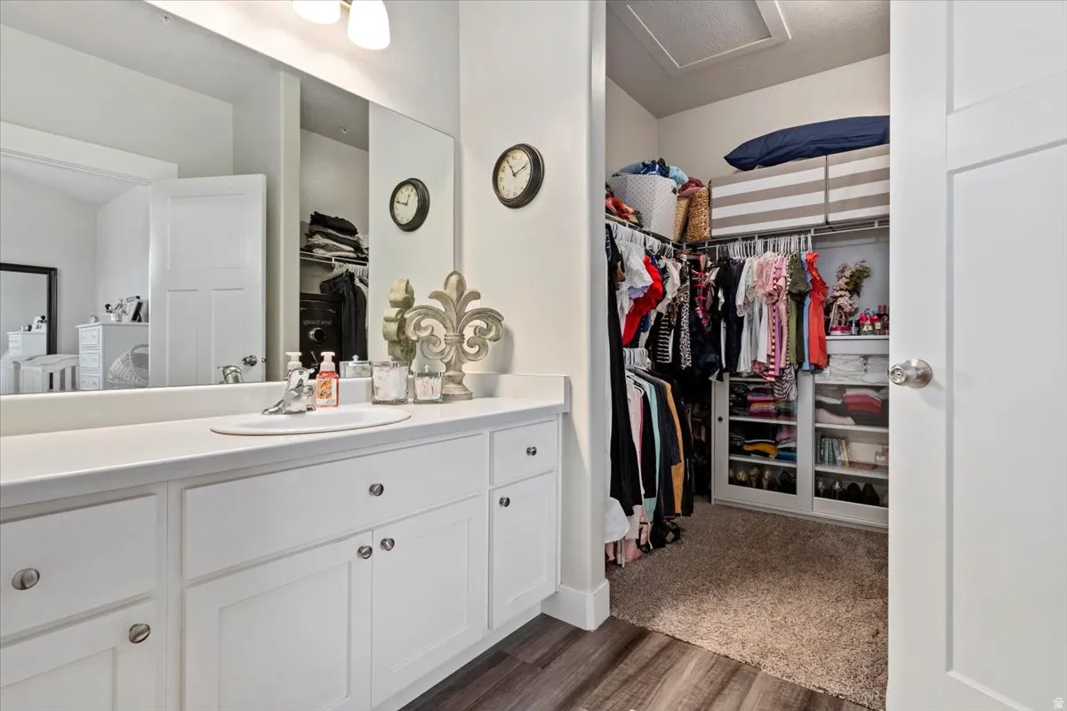 PRIMARY BATH & WALK-IN CLOSET - Bathroom vanity with a white countertop and integrated sink, complete with white cabinetry and chrome hardware