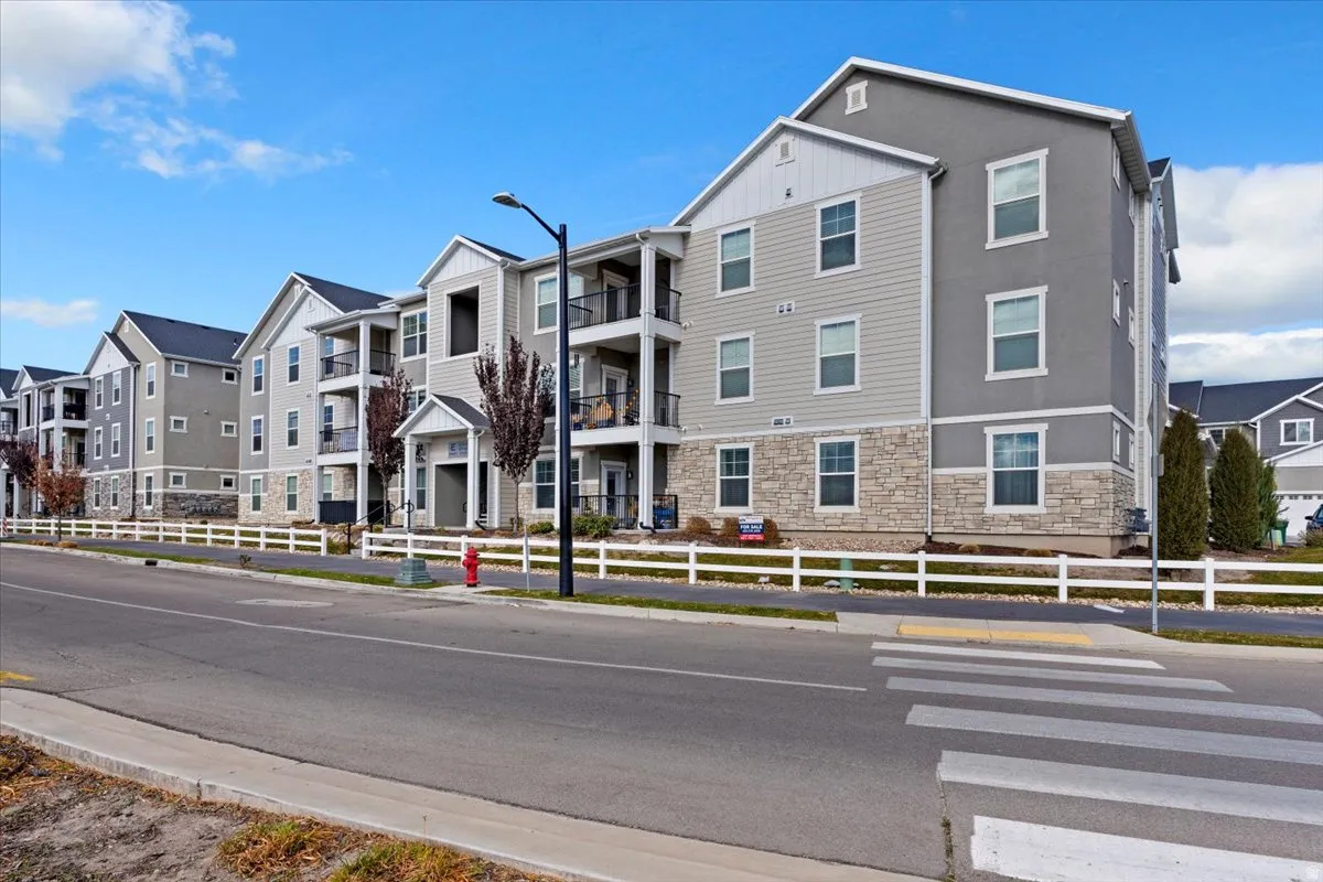 Stately multi-family dwelling with street parking.