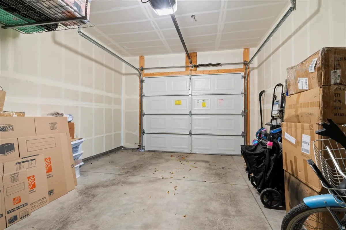 Spacious garage featuring a concrete floor, overhead wire storage rack, and an automatic garage door opener