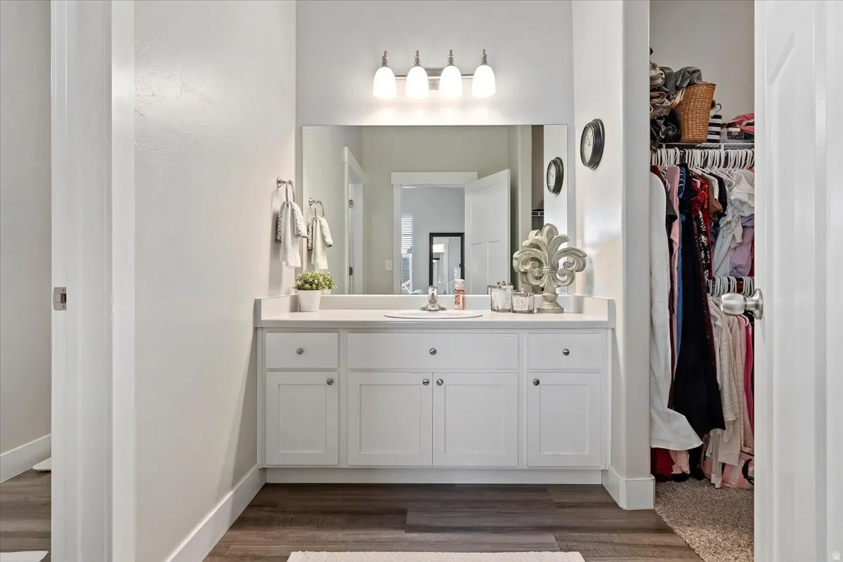 PRIMARY BATH - White vanity with a single basin, quartz countertop, and overhead light fixture