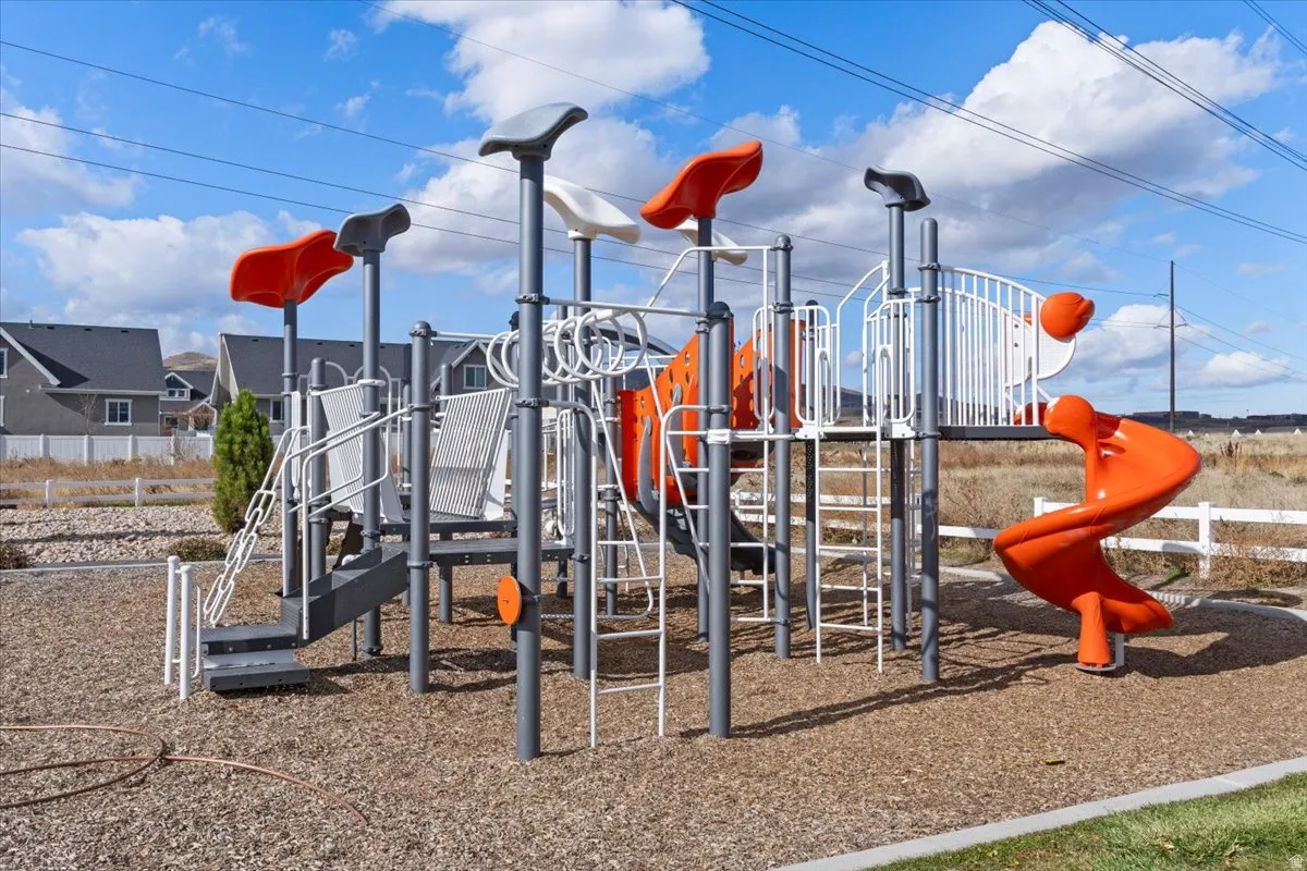 AMENITIES - Outdoor playground structure featuring multiple slides, climbing elements, and protective ground cover
