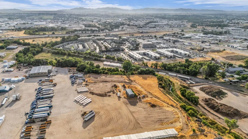 Expansive commercial property featuring a large warehouse building, multiple paved parking areas, and substantial open land