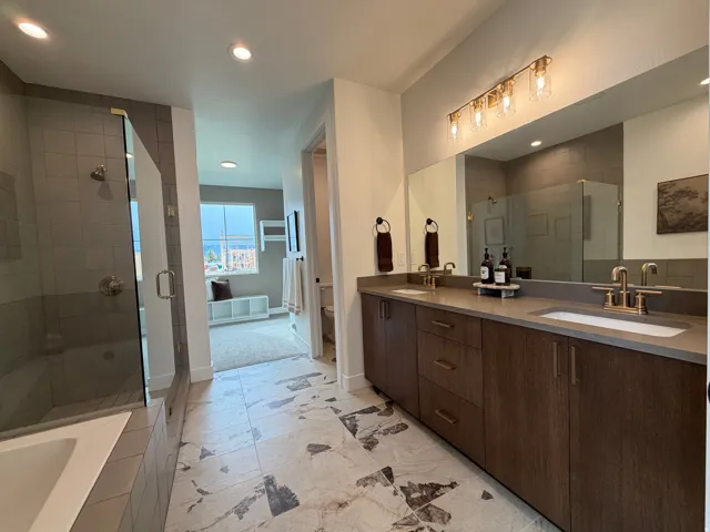Dual vanity with integrated sinks, wood-finish cabinetry, and a full-width mirror
