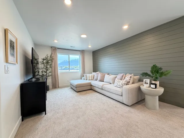Spacious living area featuring a prominent accent wall with horizontal paneling