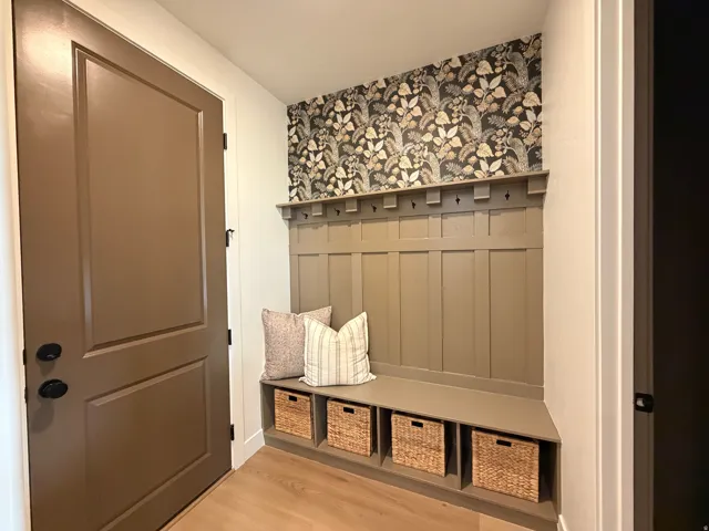 Built-in mudroom bench featuring paneled wainscoting, integrated storage cubbies, and coat hooks