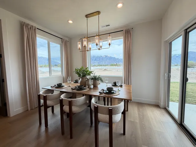Dining area featuring wood-finish flooring, recessed lighting, and a modern chandelier