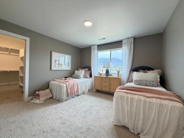 Carpeted room featuring a window with mountain scenery, a recessed ceiling light, and a built-in closet with shelving and hanging rods