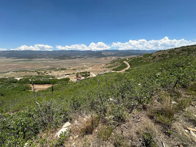 Expansive mountain and valley landscape with visible structures and winding roads