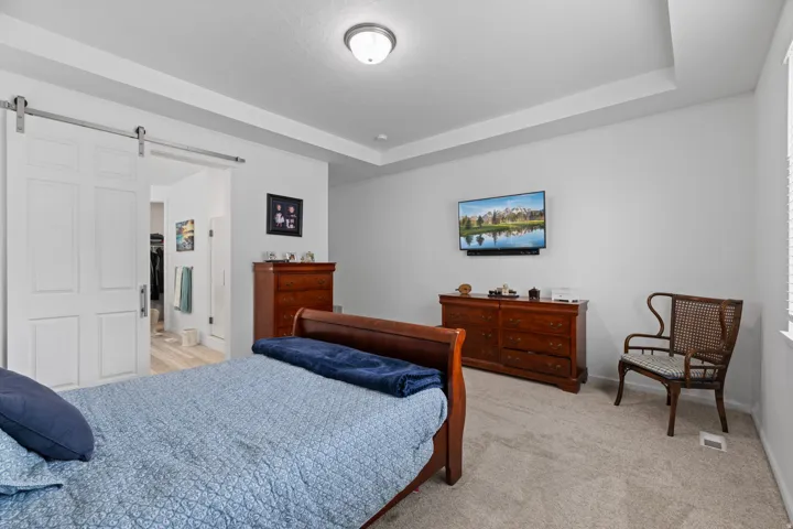 Carpeted interior space featuring a tray ceiling with recessed lighting