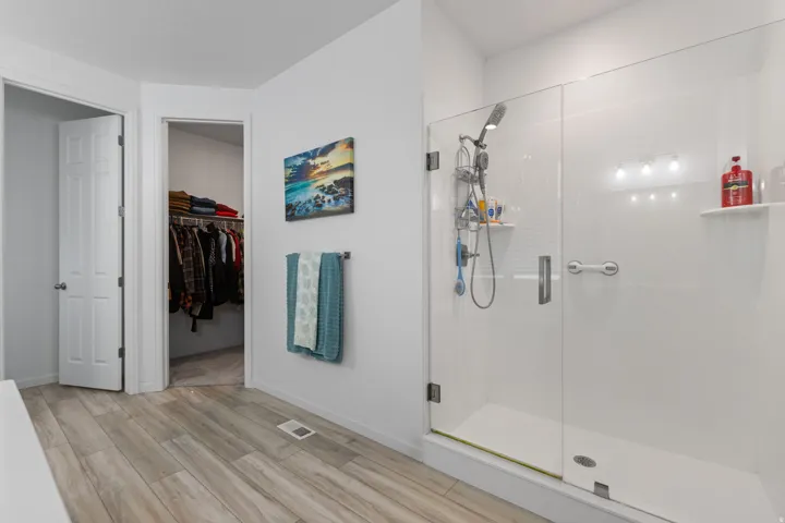 Spacious walk-in shower with clear glass enclosure and white subway tile surround