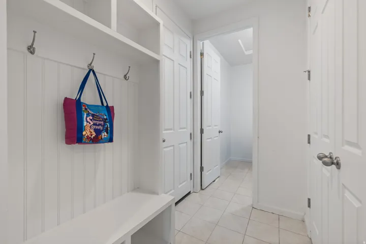 Built-in entryway storage with hooks, bench seating, and overhead shelving