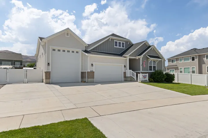 Contemporary single-story residence featuring light gray siding and a dark shingle roof
