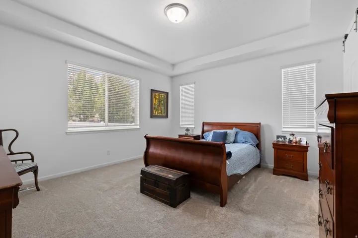 Spacious room featuring a tray ceiling and light-colored carpeting