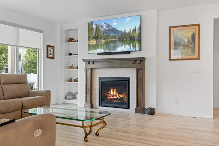 Living area featuring a fireplace with a wood mantle, a tile surround, and a hearth