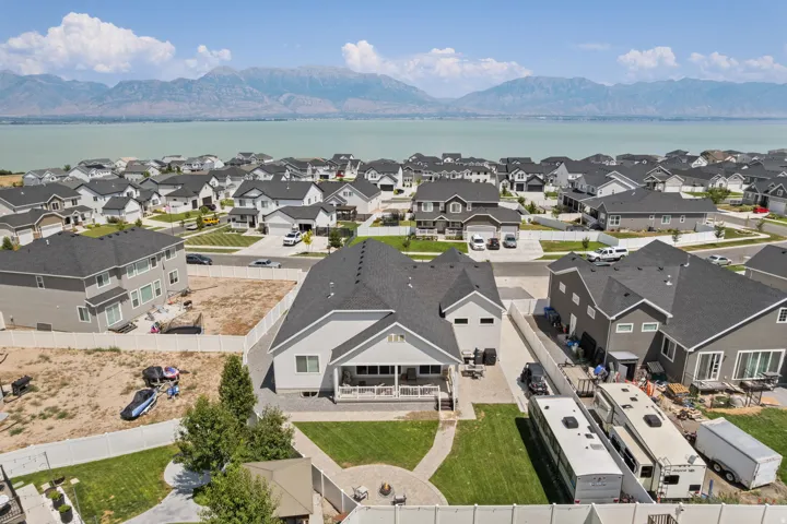 Aerial property overview showcasing a residential neighborhood with a prominent body of water and distant mountains