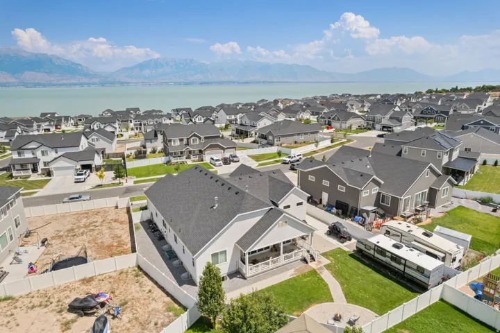 Aerial perspective showcasing a residential neighborhood with distant body of water and mountains