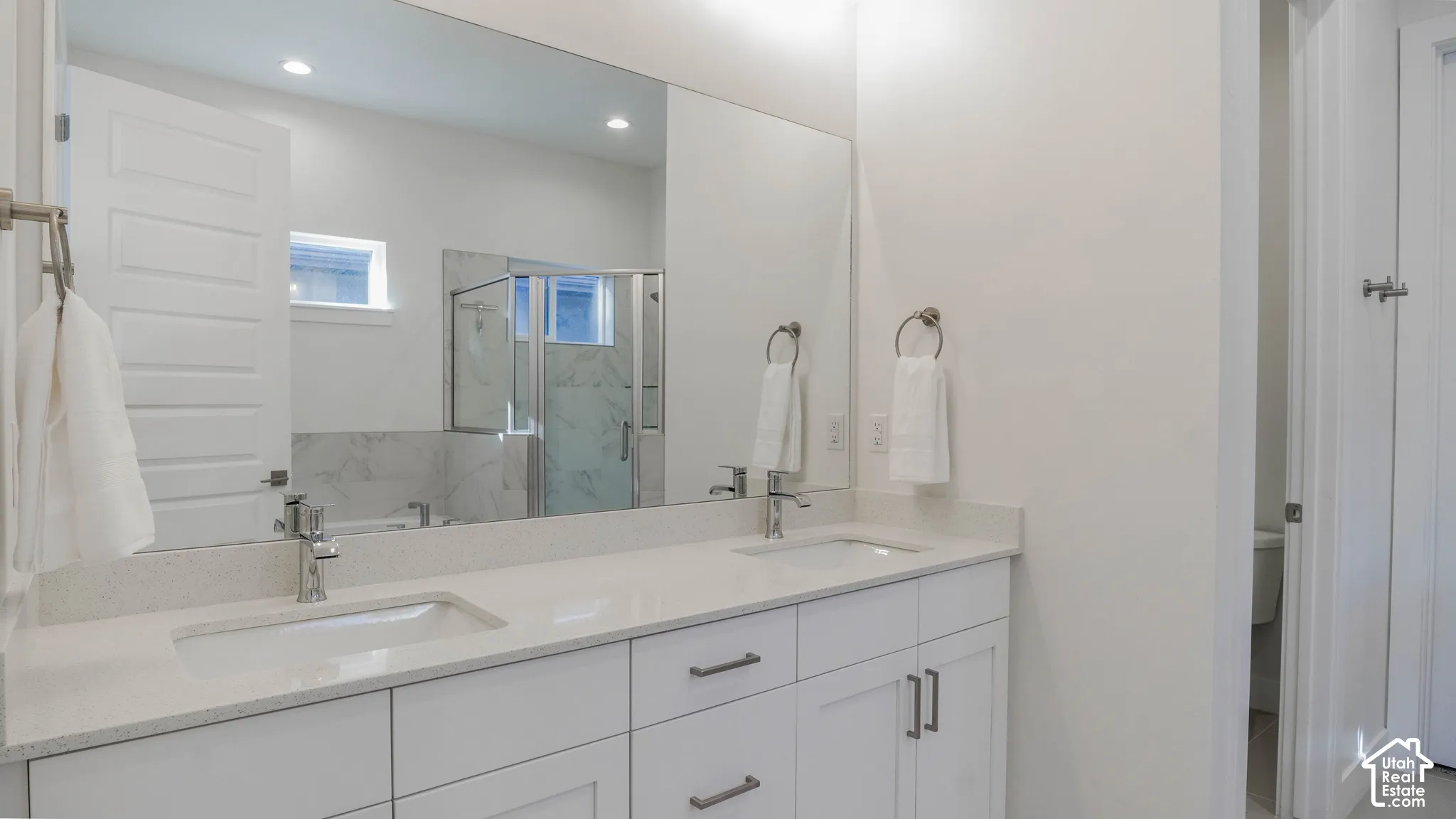 Double vanity with white cabinetry, light-toned countertops, and dual undermount sinks