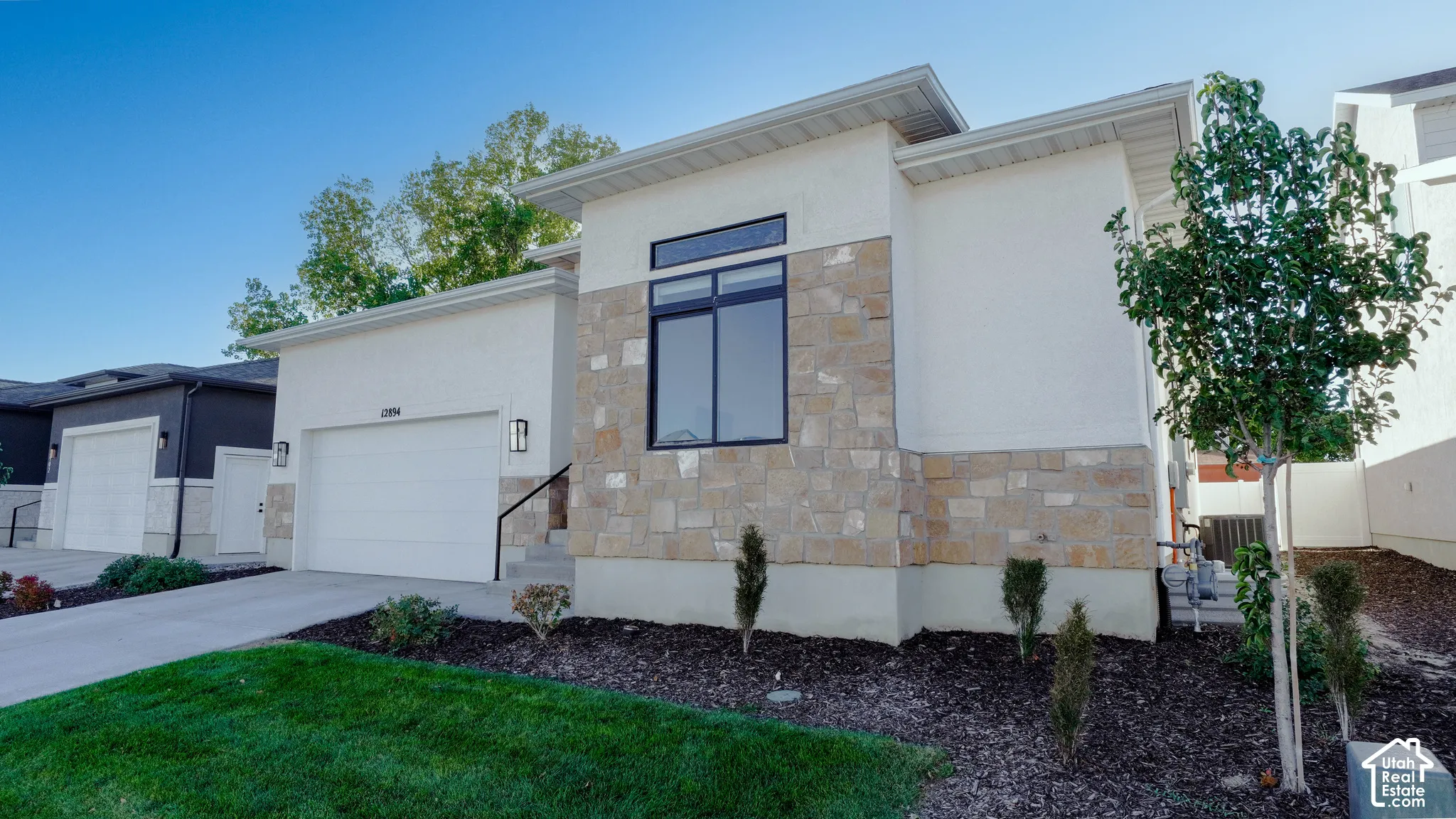 Contemporary exterior with a white stucco finish and stone accents
