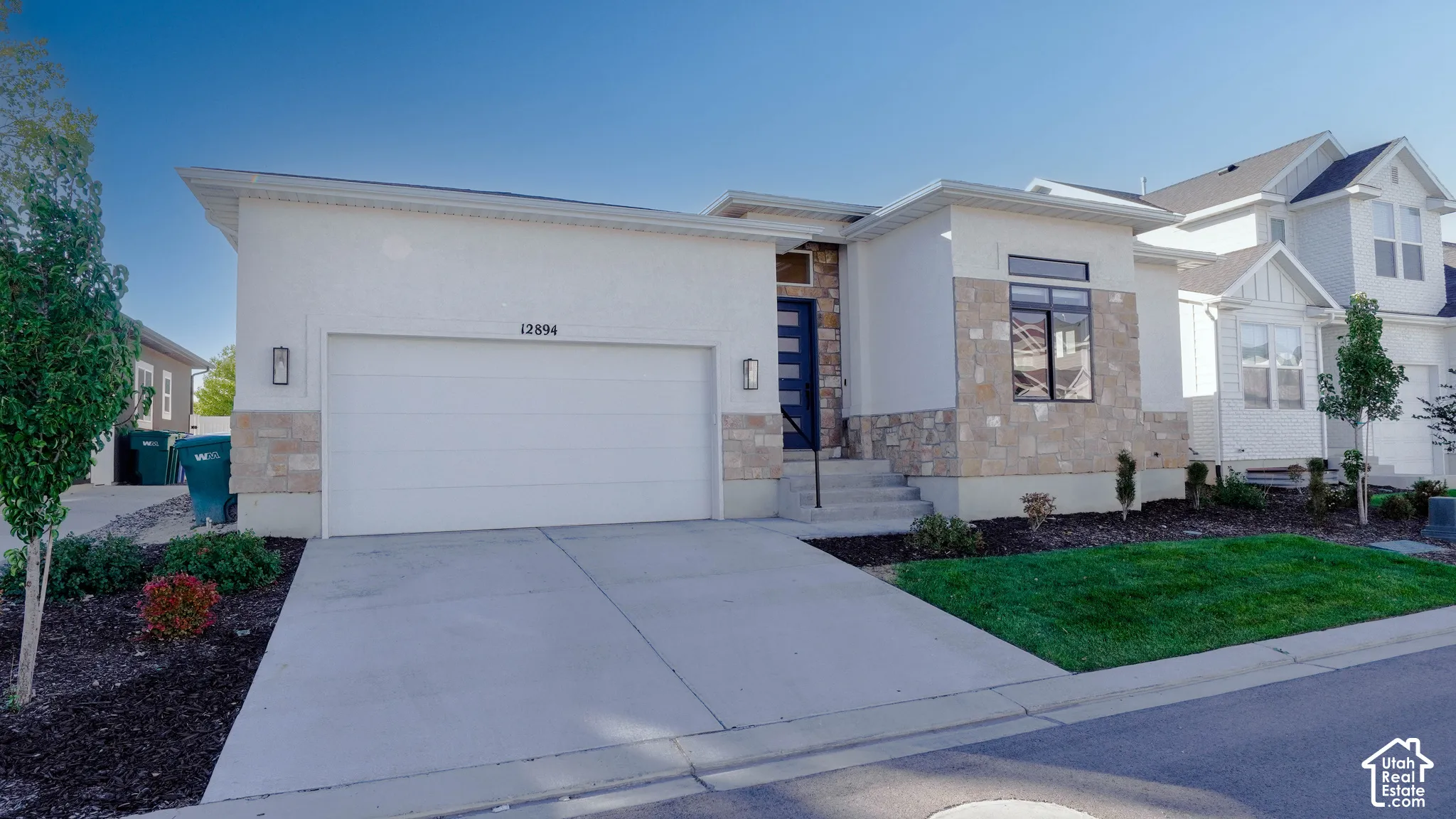 Contemporary single-story residence featuring stucco and stone veneer siding