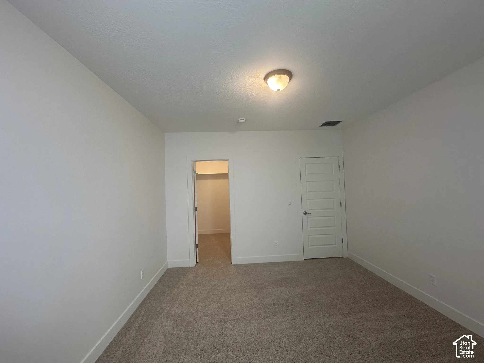 Neutral-toned carpet flooring complementing bright white walls