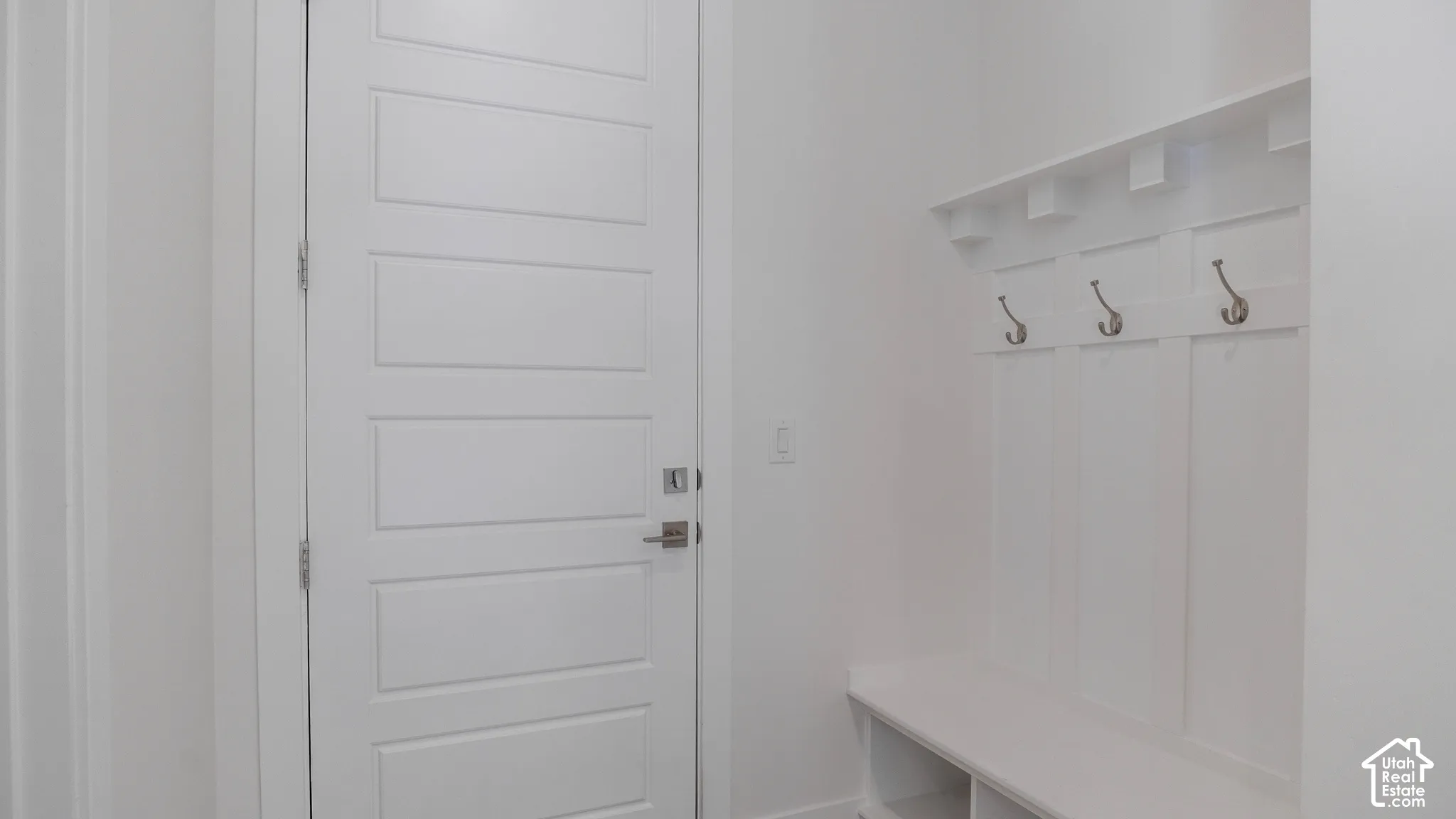 Built-in entryway bench with storage cubbies and wall-mounted coat hooks