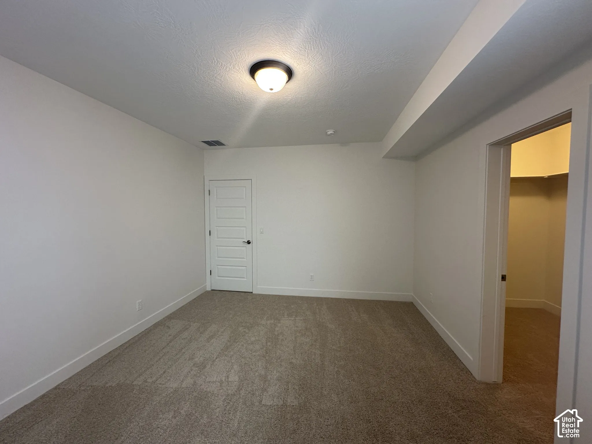 Neutral-toned wall-to-wall carpeting complements light-colored walls