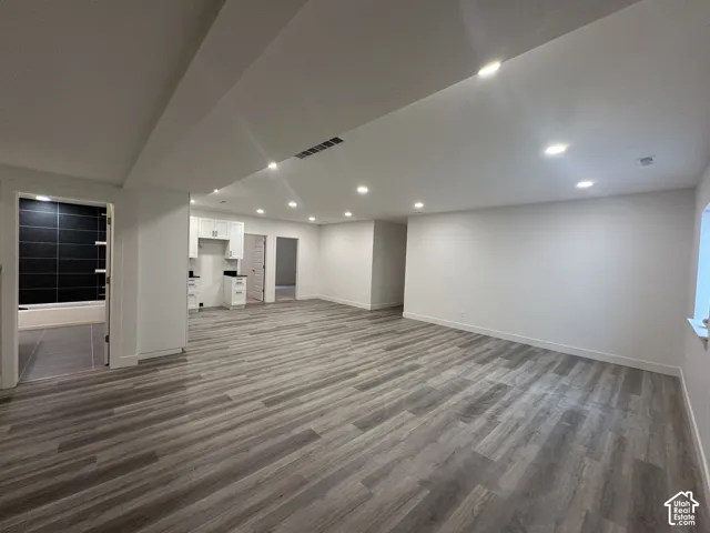 Open-concept living area featuring wood-finish flooring, recessed lighting, and white walls