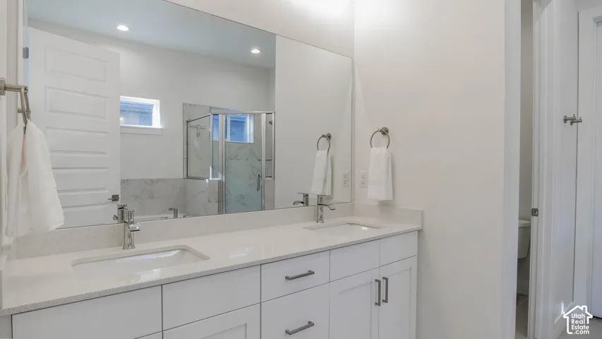 Double vanity with white cabinetry, light-toned countertops, and dual undermount sinks