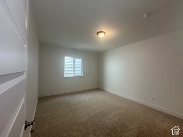 Neutral wall paint throughout the room with a single window