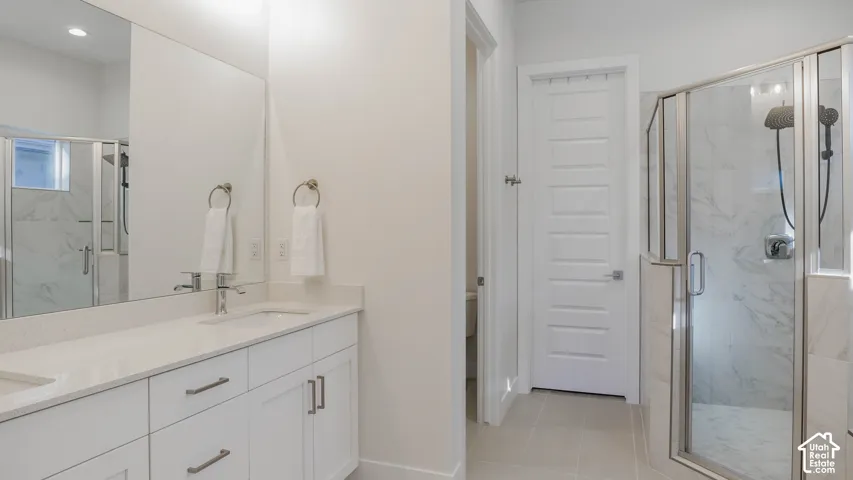 Double vanity with white cabinetry, light-toned countertops, and chrome fixtures