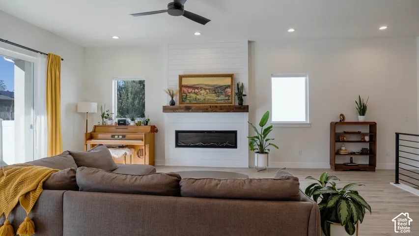 Spacious living area featuring a shiplap accent wall with an electric fireplace and a wood mantle