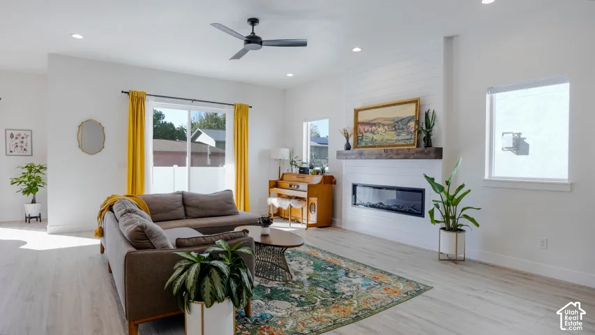 Open-concept living area featuring light wood-finish flooring, recessed lighting, and a contemporary ceiling fan