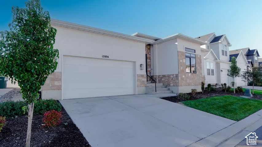 Modern two-story residence featuring a white stucco and stone veneer facade
